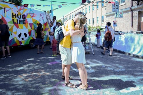 hug in front of hug life mural bus
