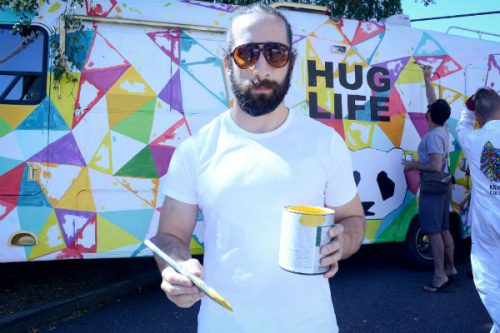 Jared Keller of Intellitonic painting hug life mural bus
