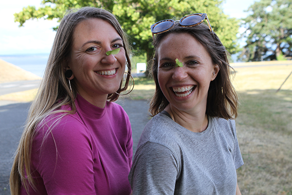 Lauren Howland and Courtney Rambo smiling with leaves on their noses